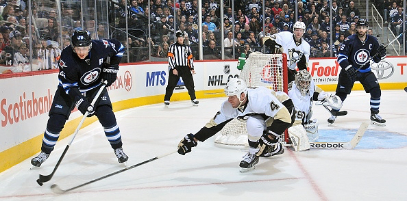 Rob Scuderi pokechecks the Jets' Blake Wheeler last Thursday in Winnipeg. -- GETTY IMAGES